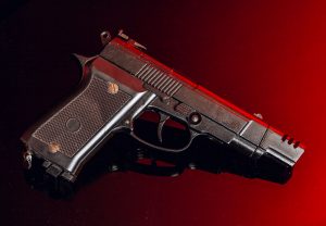 black hand gun on red background